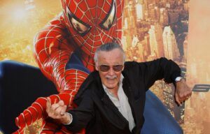 Stan Lee in front of picture of Spider-Man